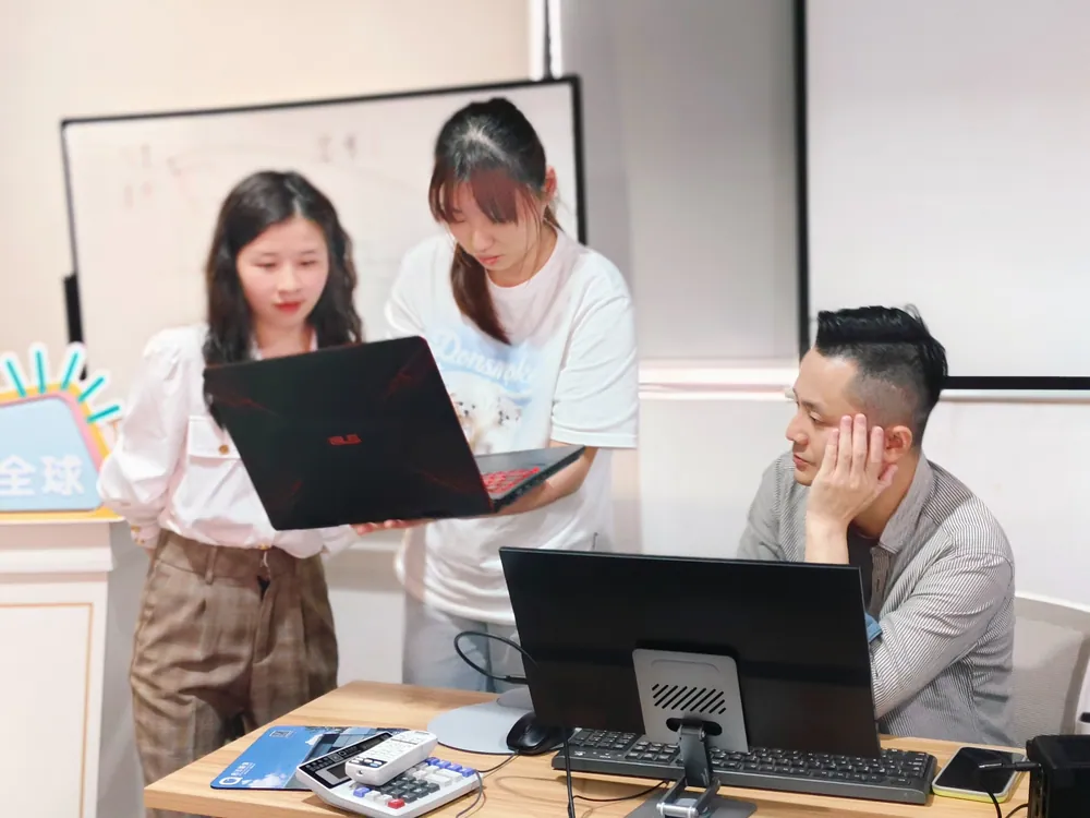 老师在电脑旁为学员提供操作指导